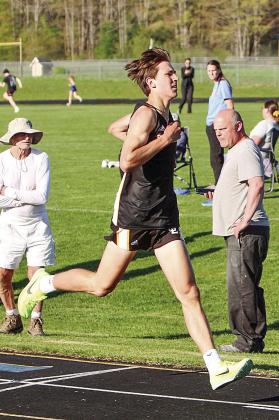 Glen Lake junior Colebrook Sutherland broke the school record for the two-mile on Monday with a time of 9:50.9. He beat the record set by Justin Kibbey in 1999 by nine seconds. Sutherland crosses the finish line as Laker long distance coach Jim Harrelsson (right) hits his timer. Photo courtesy of Nicole Bixby