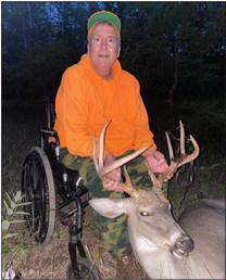 Steve Brett may have struggled to wheel to his deer blind, but he had no problem holding up the antlers on the trophy rack he shot Sunday evening. Enterprise photo by Alan Campbell