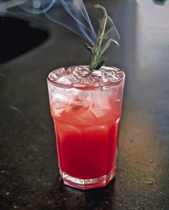 The “nourishing mind” cocktail, one of three zero-proof drinks on the last Hive Social Club menu, features Audacia’s floral berry elixir paired with Hive housemade raspberry syrup and Alchemy &amp; Co’s nourish herbal tea, garnished with a smoking sprig of rosemary. Photo courtesy of Nicole McDaid