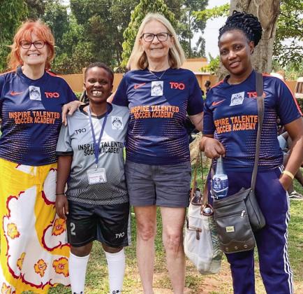 Courtesy photo Mary Taylor (left) and Judy Yoder (right) stand with women soccer players in Uganda a few year ago. A nonprofi t soccer program created by Leland seventh graders in 2016 has grown from 20 to 500, but recent developments have resulted in a fundraising effort to purchase the soccer fields in Uganda.