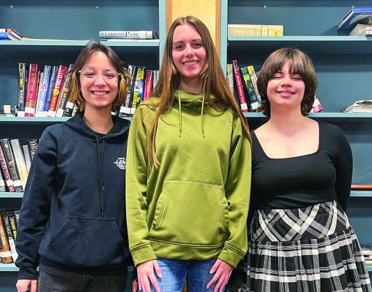 Suttons Bay High School students (from left to right) Reegan Craker, Isabel Schmidt, and Minnie Bardenhagen are pictured at school on Monday. Schmidt and Bardenhagen are finalists in this year’s Young Playwright Festival at the City Opera House, and Craker is a semi-finalist. The three students are in “Writers Studio,” one of 22 programs operated by Northwest Education Services’ Career Tech Center. Enterprise photo by Meakalia Previch-Liu