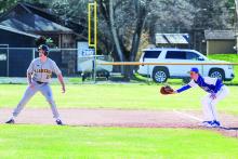 Enterprise photos by Brian Freiberger St. Mary first baseman Cody Couturier tries to hold Glen Lake base runner Joey Roux on first.