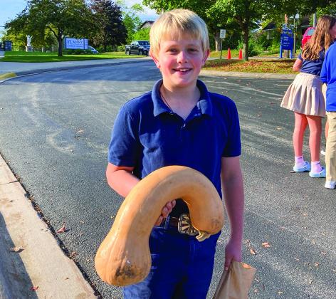 Kenneth Grant chose a large butternut squash to feed his chickens at the St. Mary Outdoor Farmers Market last week. Photo courtesy St. Mary School