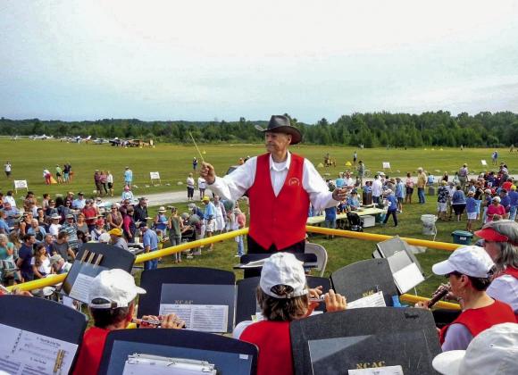 Don Wilcox, long time Northport Community Band (NCB) conductor, is seen performing at Woolsey Memorial Airport during the Northport Lions Club Drive-In, Fly-In pancake breakfast earlier this month. A tribute for Wilcox to commemorate his recent induction into the National Band Association’s Hall of Fame is set for the upcoming NCB Sousa Concert on Saturday, August 27. Photo courtesy of Dolly Martinson
