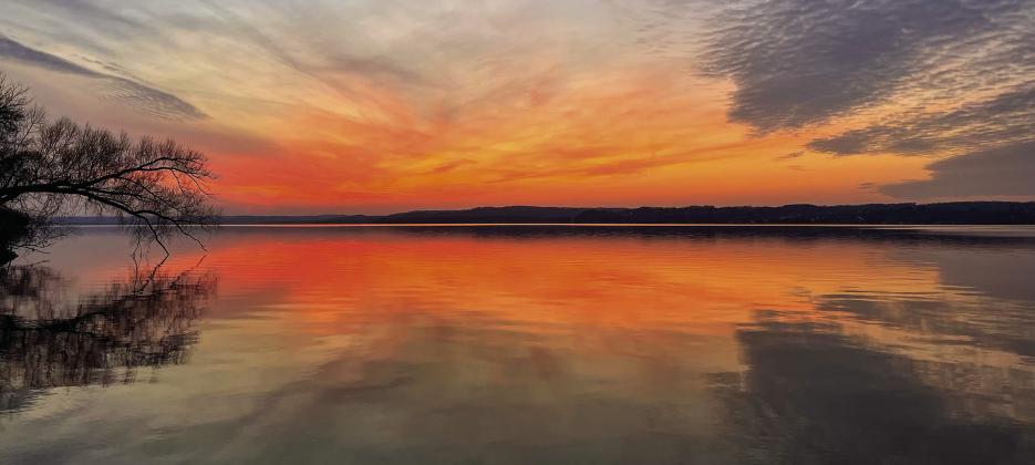 A warm colored sunset over Lake Leelanau is seen at Bingham Boat Launch on the evening of the winter solstice last Thursday. The celebration of the winter solstice marks the shortest day of the year and the longest night in the hemisphere. Enterprise photo by Meakalia Previch-Liu