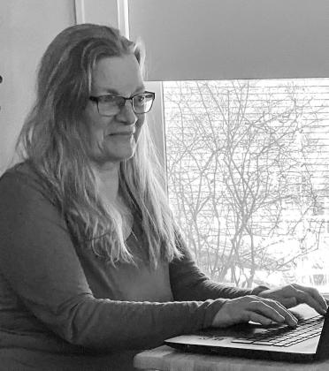 Northport resident Laura Kalchik is pictured writing her final “From the Heart” editorial for the 25th anniversary/farewell edition of her publication “Families First Monthly.” Courtesy photo
