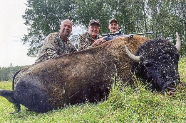 Sons Ken, left, and Mike Garvin flank their father, Alex, after organizing a buffalo hunt on a game farm in the Upper Peninsula.