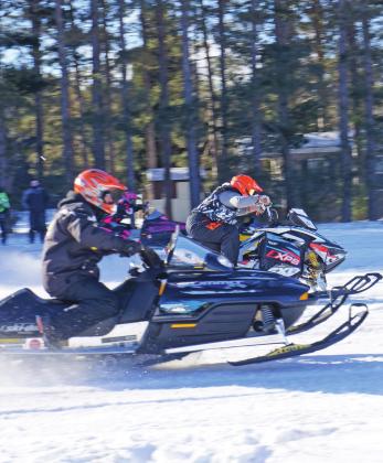 Snowmobile drag racers launch from the starting line last year at the annual Roy Taghon Memorial Snowmobile Drag Race at Empire Airport. Enterprise file photo