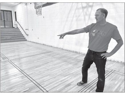 Suttons Bay Public Schools Superintendent Casey Petz is seen displaying recent additions made in the elementary gym. The floors, walls, and decals were redone so it could serve more as a multipurpose area. The new floor stripings and lines will allow for activities like four-square, volleyball, and pickleball. Enterprise photo by Meakalia Previch-Liu