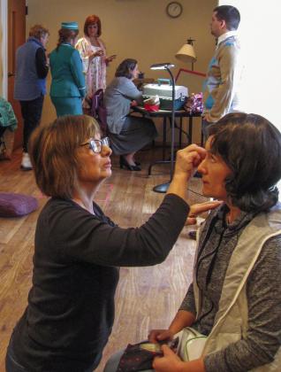 At front, Karen Cross applies makeup to Monica Carman in 2017 for the Northport Performing Arts Center theater production “Boeing, Boeing.” In the background, from left to right, Costumer Janet Crane advises actors Danielle Hartley, Emily Julien, Bonnie Deigh, and Joel Hoard on costumes and makeup. Photo courtesy of Joe Thatcher