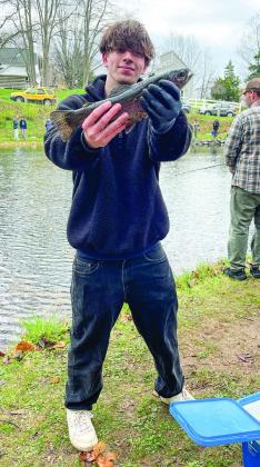 Karl Krusel of Omena, pictured here after catching one of the many rainbow trout in the Mill Pond, was home for the weekend from Grand Valley State University and made time to participate in the annual fishing day event.