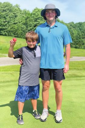 Travis Coleman, 9, hit a hole in one at Bahle Farms in Suttons Bay on Tuesday. He is pictured here with his older brother, Ethan. Enterprise photo by Brian Freiberger